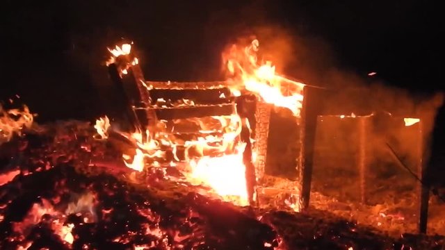 Table and bench burning in a huge fire. Hot seat, isn't it? Zoom in.
