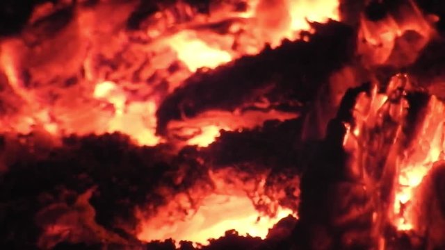 Huge solstice campfire burning in the black of night. Closeup. Hot glowing wood.
