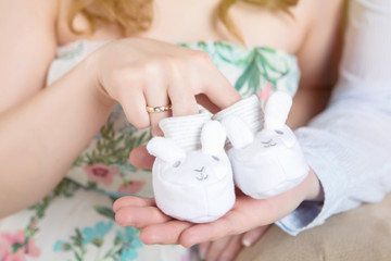 Crop couple with tiny footwear on hands