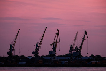 Fototapeta premium Wharf Cranes In Front Of Sunset Sky