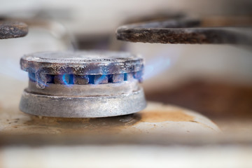 Close-up of dirty gas stove burning fire