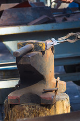 blacksmith performs the forging of hot glowing metal on the anvil