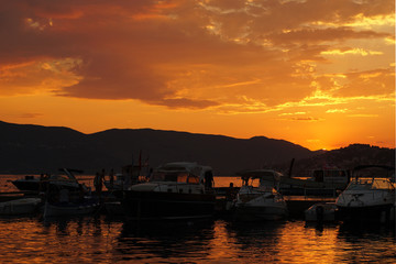 Fototapeta na wymiar sunset over a docks in the marine with people & boats 