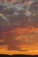 Naklejka na ściany i meble Orange cloudy sky during a sunset