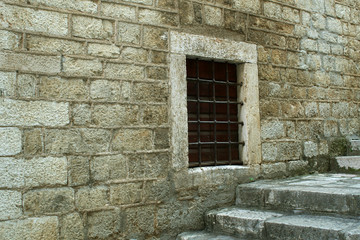 Fototapeta na wymiar Traditional house made from stone, with a barred up window