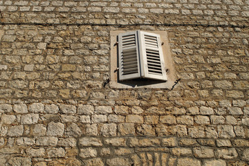 Old traditional building with white wooden window covers