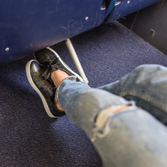 Female passenger stretching her legs on long commercial airplane flight. Exit seats with more leg space for more comfortable flight.