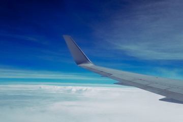 Wing of airplane in the air with cloud