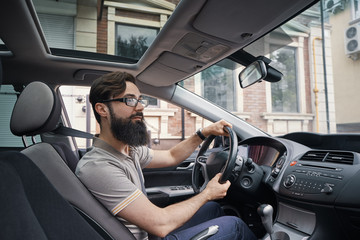 Happy charismatic man driving a car