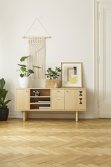 Vintage cabinet with plants, poster and wall decoration with a wooden parquet