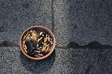 Trister Aschenbecher auf Asphalt