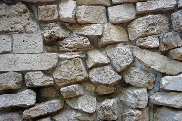 The wall of natural stones of different sizes.