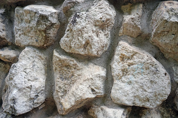 The wall of natural stones of different sizes.