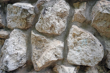 The wall of natural stones of different sizes.