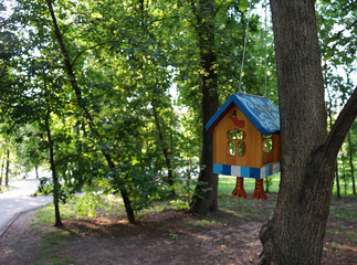 The original house for birds on a tree branch in the city Park.