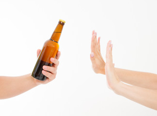 female hand reject a bottle of beer isolated on white background.anti alcohol concept. Copy space