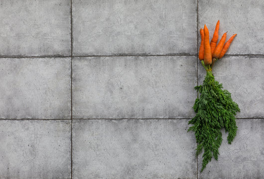 carrots with greens on a gray stone table