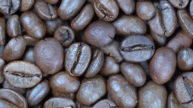Fried coffee beans background, close up, rotation loopable 4k top view. Food  background. Gastronomy concept, organic food. Macro coffee beans