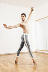 Young beautiful male  ballett dancer posing in studio