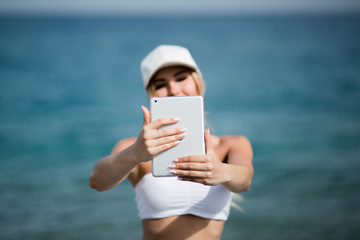 healthy gym blonde girl searches for new lifestyle fitness apps on her computer tablet