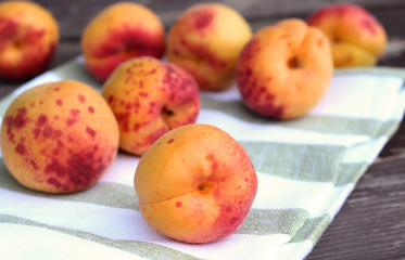Ripe organic apricots on the wooden background. Space for text. Blurred background.
