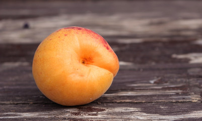 Ripe organic apricots on the wooden background. Space for text. Blurred background.