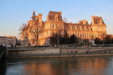 Fototapeta na wymiar Paris, vue sur l'Hôtel de Ville et les quais de Seine au soleil couchant (France)