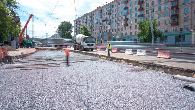 Concrete works for road maintenance construction with many workers and mixer timelapse
