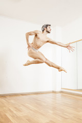 Young beautiful male  ballett dancer jumping in studio