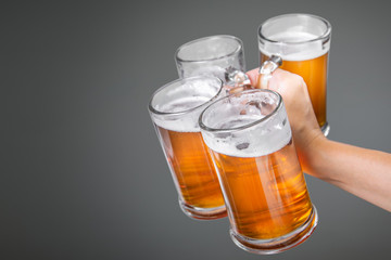 Oktoberfest concept - hand holding glasses with beer