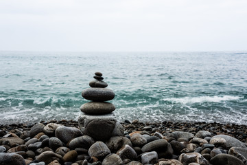 Fototapeta na wymiar stack of zen stones pyramid on beach
