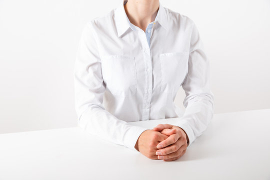 Business woman in white sitting at a desk.