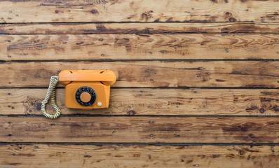 vintage orange phone on an old wooden table