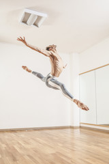 Young beautiful male  ballett dancer jumping in studio