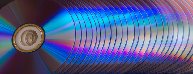 sd and dvd disks on a dark background. large stack.