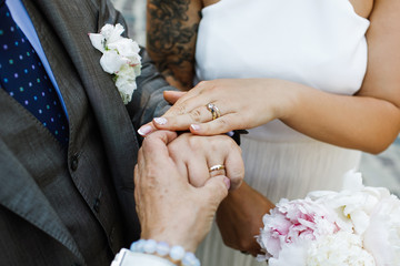 Obraz na płótnie Canvas Bride and groom show their hands with wedding rings