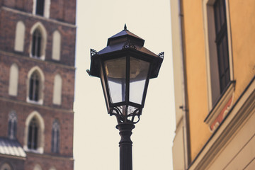 Fototapeta na wymiar old city street concept wit metal lantern on foreground between unfocused buildings on background