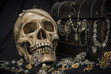 Still life with a human skull with old treasure chest and gold, diamond