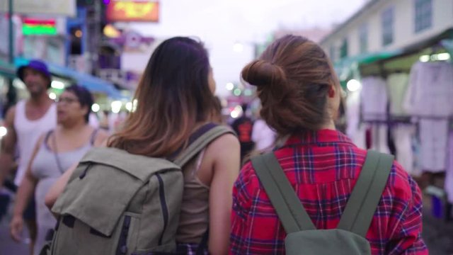 Traveler backpacker Asian women lesbian lgbt couple travel in Bangkok, Thailand. Female drinking alcohol or beer at The Khaosan Road the most famous street in Bangkok.
