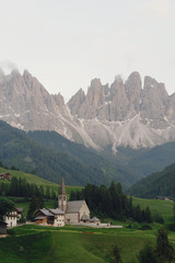 Look from afar at a church somewhere in Italian Dolomites