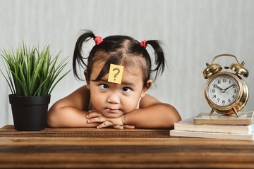 cute and confused lookian asian toddler with question mark on her forehead. concept of child...