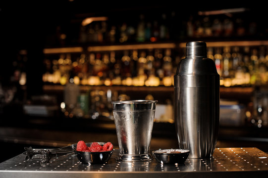 Professional bar equipment, shaker, glass and tongs arranged on the bar counter