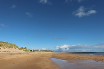 Fototapeta na wymiar Blue sky with copy space over dunes, beach and sea