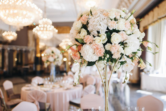 Pink and white wedding bouquet stands in the middle of dinner table