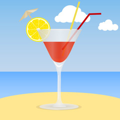 Cocktail on the beach. A glass of cocktail with an lemon slice on the sand against the background of the sea and sky. The concept of a beach holiday.