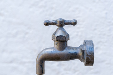 Wasserhahn vor einer weißen Wand