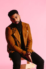 Stylish, handsome and cool African American man with beard, isolated on pink studio background