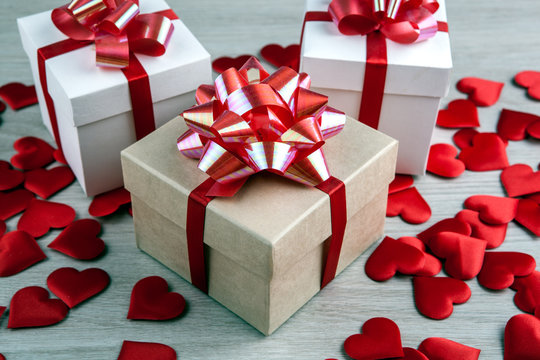 three gift boxes on a gray background and textile heart shapes
