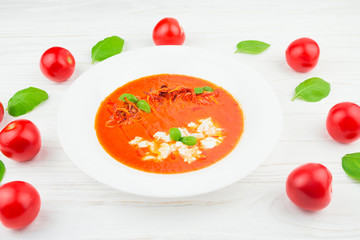 tomato soup on a wooden background, closeup