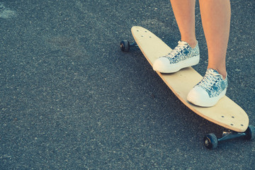 Girls legs standing on longboard closeup and a lot of copyspace